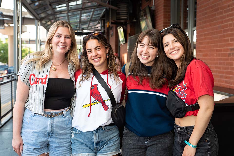 A group of students pose for a photo wearing Cardinals Baseball shirts.