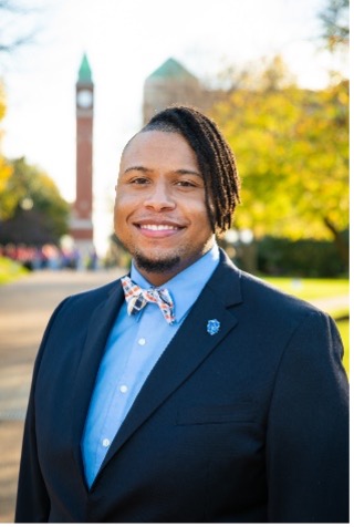 Aric Hamilton stands in front of the SLU clock tower