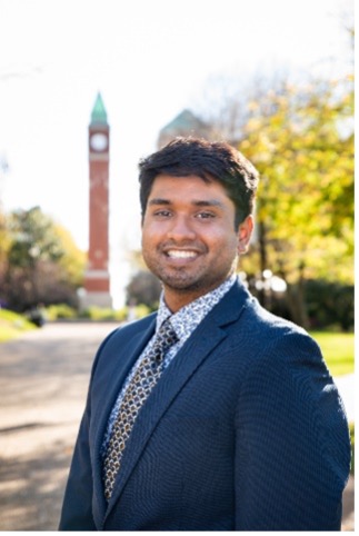 Ajit Perla stands in front of the SLU clock tower