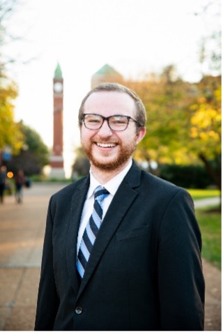 Blake Recupido stands in front of the SLU clock tower