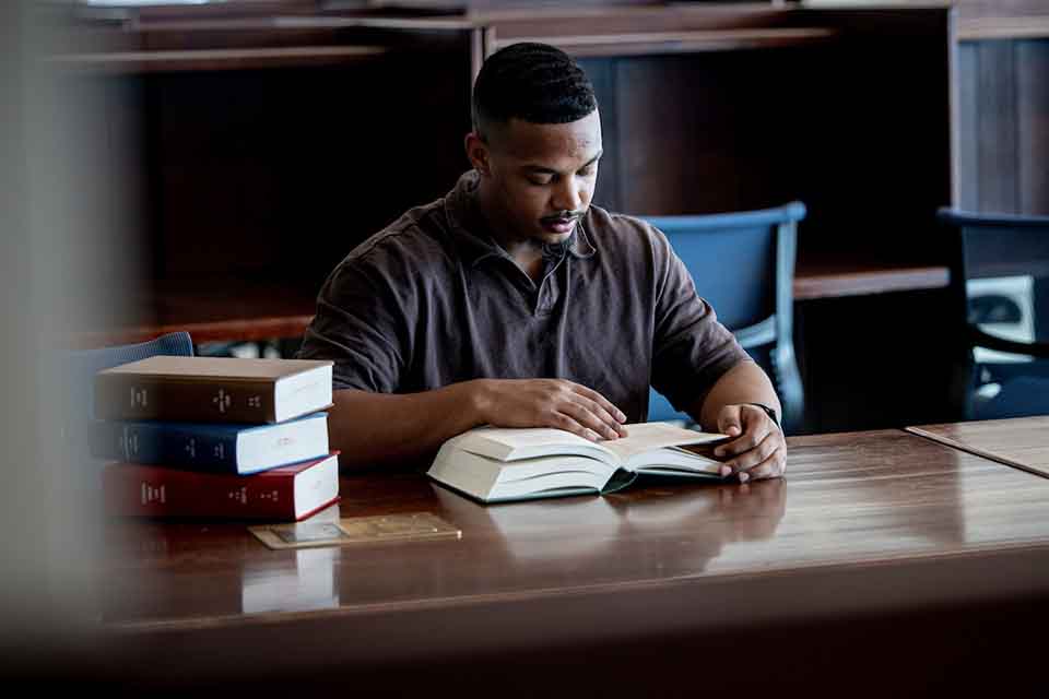 Jaylen Riley studies at a table with books in front of him