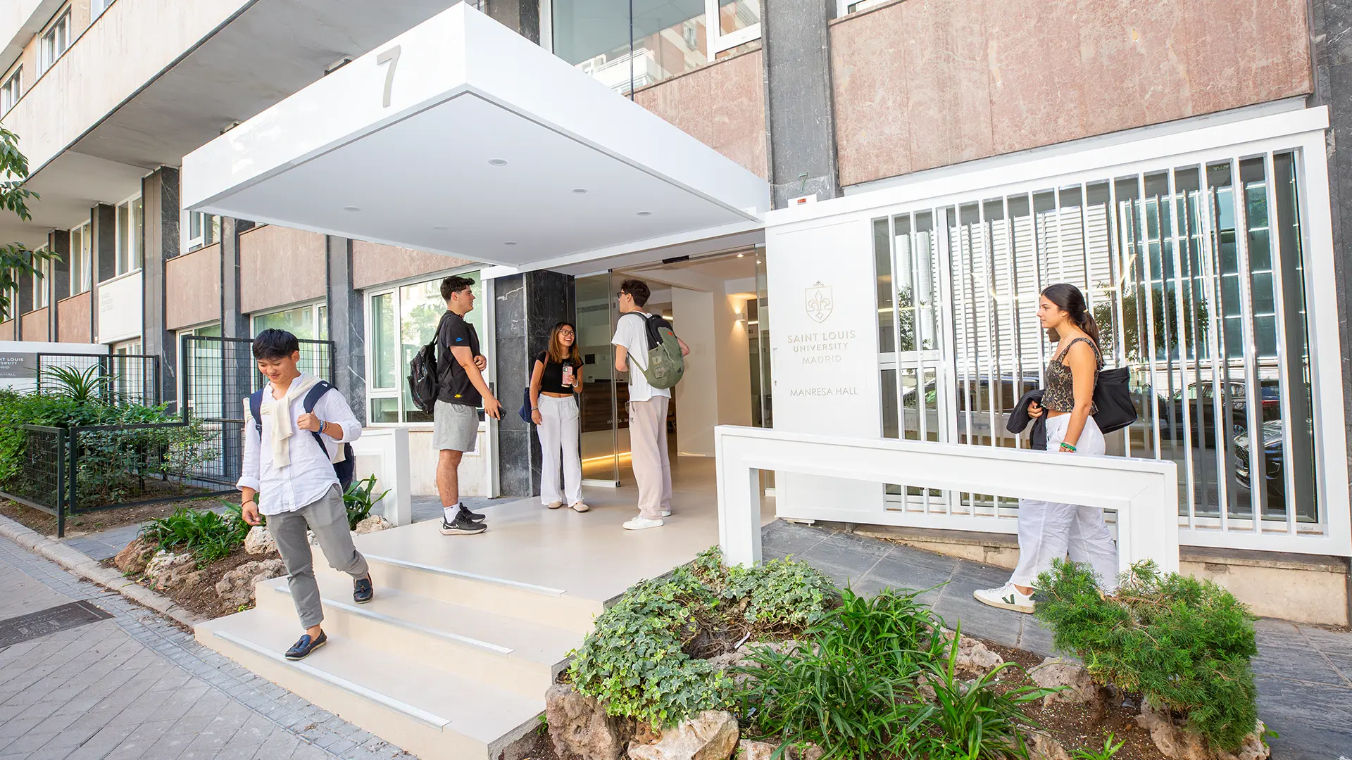 A view of Manresa Hall, one of the university's buildings, with students entering and leaving the building as they head to their classes.