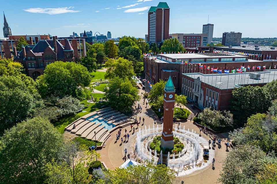 An aerial view of Saint Louis University's campus with the clock tower at the center and students walking around West Pine Mall