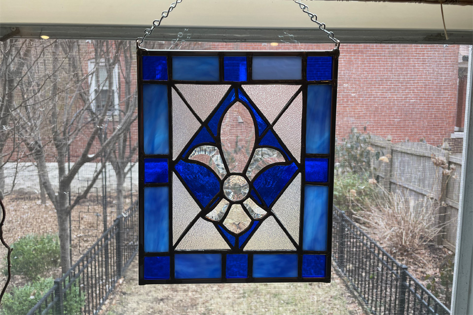 A picture of a blue stained glass piece made by faculty member