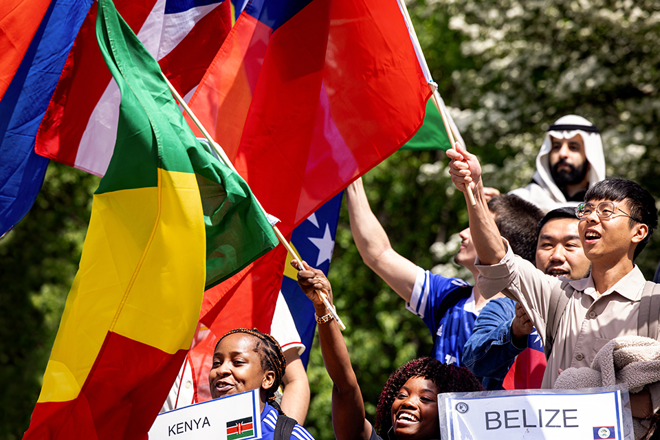 A group of people wave flags at a parade. 