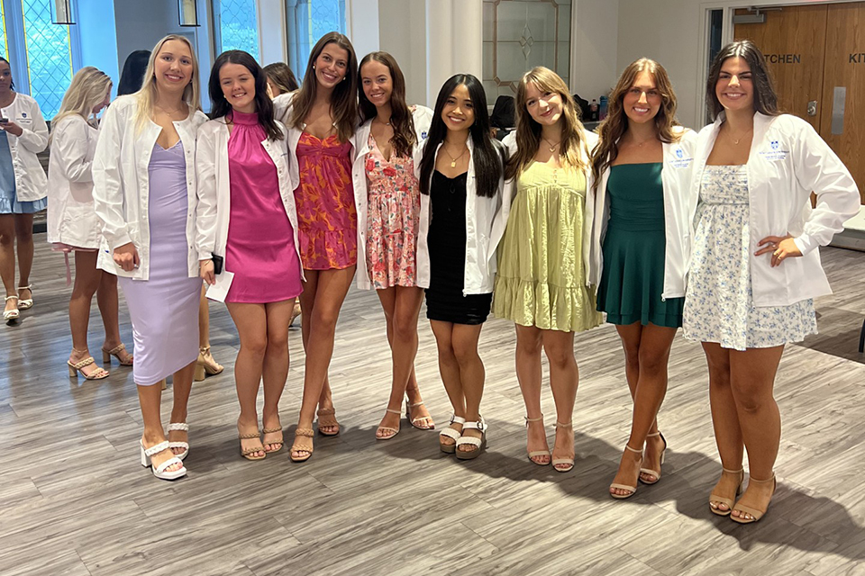 A group of female students pose for a photo at a reception.